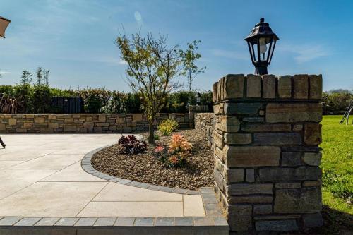 Stone pillar and wall with flower bed