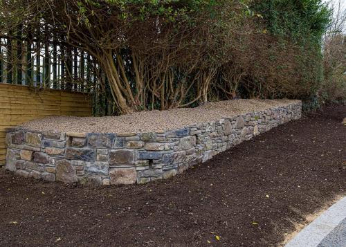 Raised garden bed with trees and stone masonry